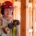 Woman construction worker wearing a red construction hat and using a drill on a house construction project.