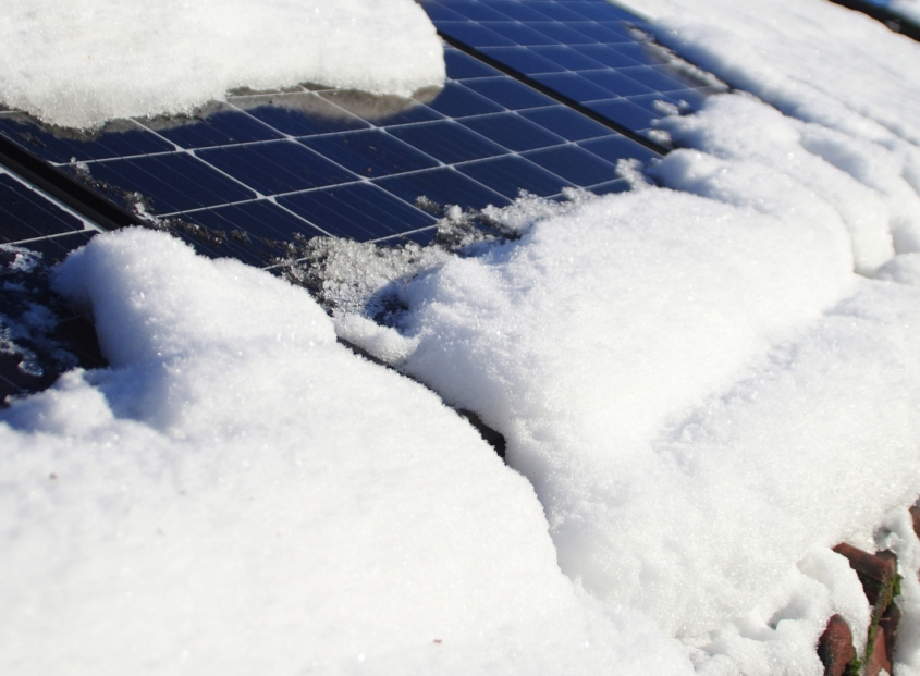 Residential solar panels covered in ice and snow.