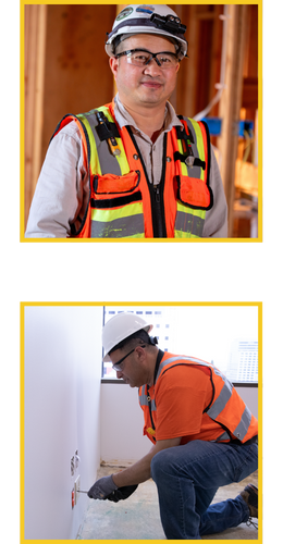 Female electrician smiling and wearing a hard hat while holding tools.