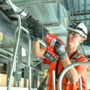 Commercial electrician installs conduit in a large warehouse.