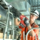 Commercial electrician installs conduit in a large warehouse.