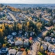 Aerial view of a suburban neighborhood with streets, houses, and autumn trees.