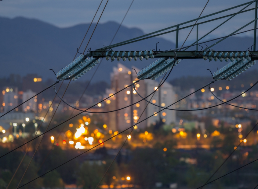 Portland skyline at night with electrical pole and wires.