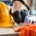Hard hat, hearing protection ear muffs, protective goggles, and gloves on a table.