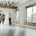Realtor shows two people the inside of a commercial building with large windows and wood floor.
