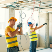 Construction electricians in new commercial building setting up electric.