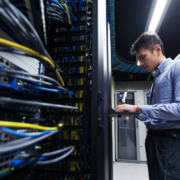 Worker on a data center typing at a terminal.