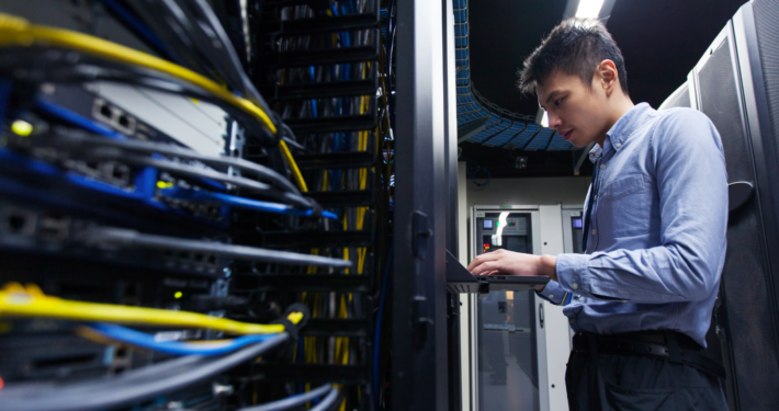 Worker on a data center typing at a terminal.