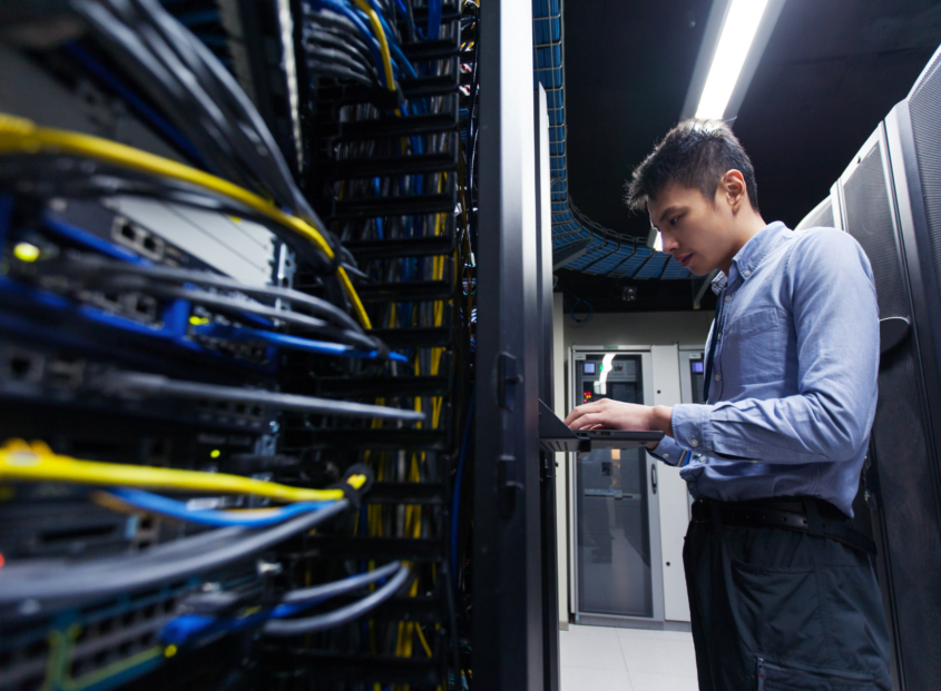 Worker on a data center typing at a terminal.